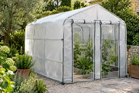 Serre Outsunny à bâche blanche renforcée, deux portes enroulables et châssis en acier dans un jardin