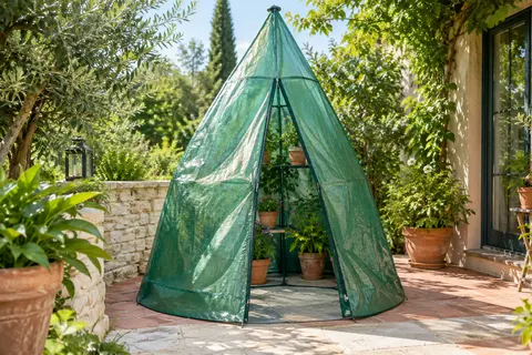Serre tipi verte Vounot installée sur une terrasse, avec des plantes en pots à l’abri